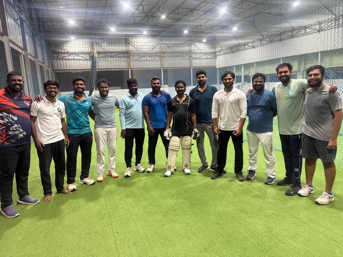Adult players standing together on the indoor turf at the Chennai academy in Medavakkam after a session.
